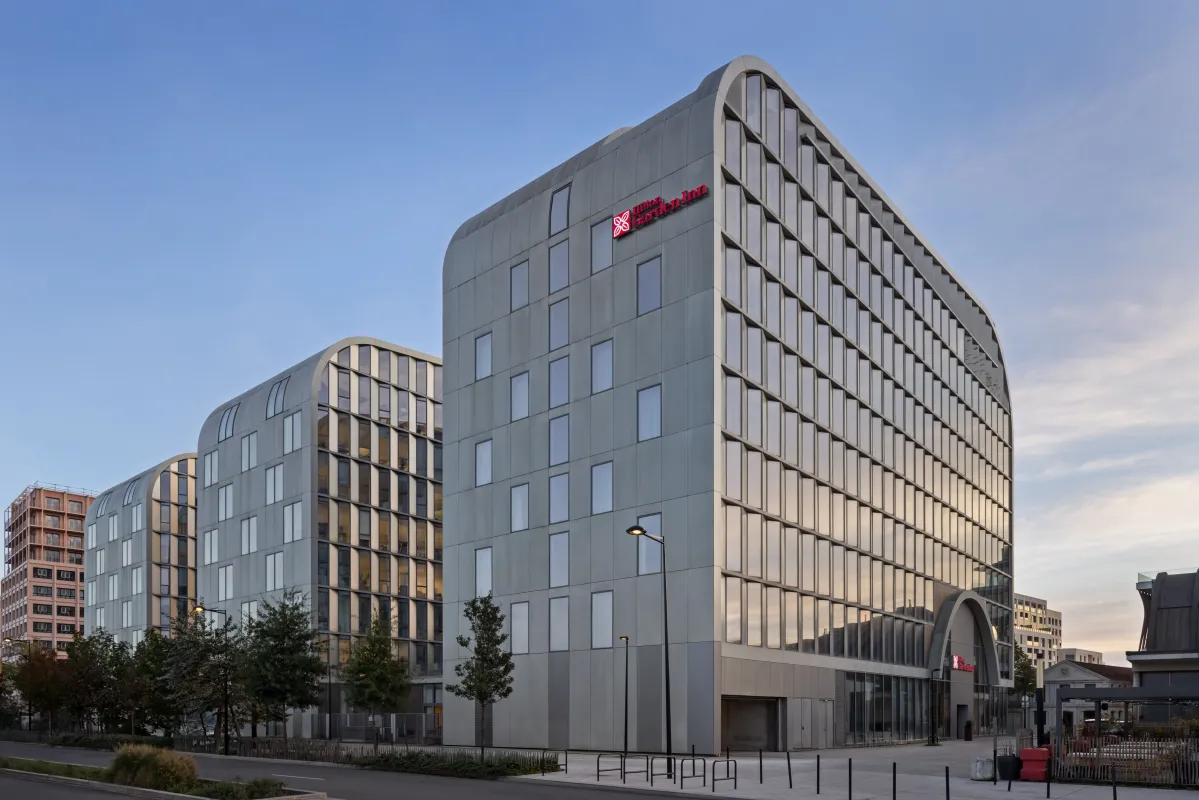 Bâtiment moderne de l'hôtel Hilton Garden Inn à Bordeaux centre-ville, présentant une architecture contemporaine avec façade grise, panneaux nervurés verticaux, plusieurs étages aux fenêtres régulières, et entrée au rez-de-chaussée, dans un environnement 