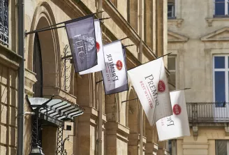 Bannières suspendues de l'hôtel Best Western Premier affichant les logos sur la façade d'un immeuble de style haussmannien à Bordeaux