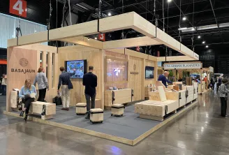 Stand d'exposition en bois au Congrès Woodrise de Bordeaux présentant une structure en bois moderne avec écrans d'affichage, espaces d'accueil pour visiteurs et signalétique BASAJAUN et EPA Urban Planners