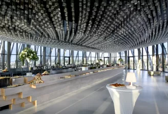 Espace événementiel moderne en hauteur avec baies vitrées panoramiques, service de restauration élégant, plafond en cristal spectaculaire et vues expansives sur Bordeaux