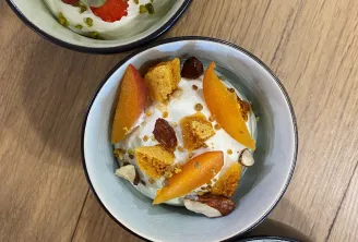 Trois bols de desserts crémeux garnis de fruits frais et de fruits secs sur une surface en bois. Le bol supérieur présente des fraises et des pistaches, le bol du milieu des abricots et des fruits secs, le bol inférieur des betteraves et des amandes.