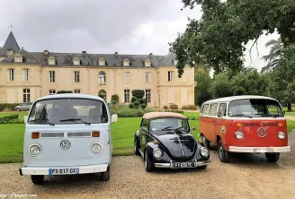 Trois véhicules Volkswagen classiques garés devant un château historique sur une allée gravillonnée, entourés de pelouses vertes et d'arbres dans la région de Bordeaux.