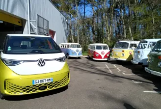 Collection de véhicules Volkswagen incluant un ID.Buzz électrique jaune moderne et des camping-cars VW classiques de différentes couleurs garés à l'événement Vintage Camper de Bordeaux